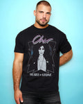 Man wearing a black t-shirt with Cher Heart of stone 1989 tour design against a light blue background