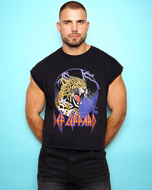 Man wearing a black sleeveless shirt with a Def Leppard logo on a light blue background