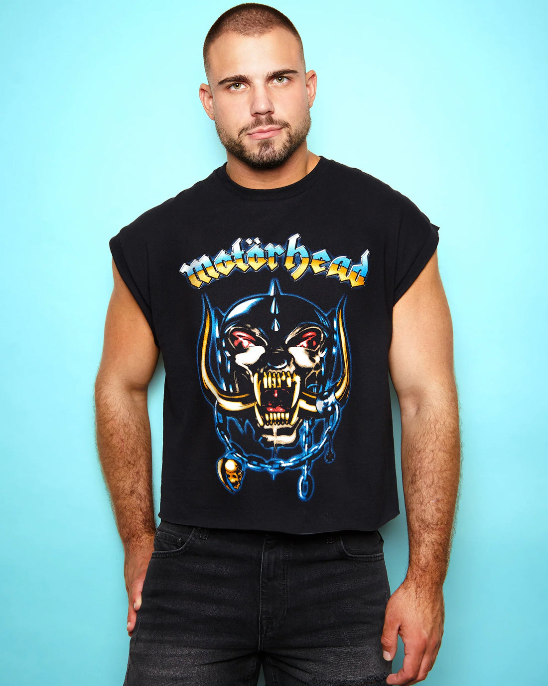 Man wearing a black sleeveless shirt with a graphic design and 'Motorhead Airbrush' text against a light blue background