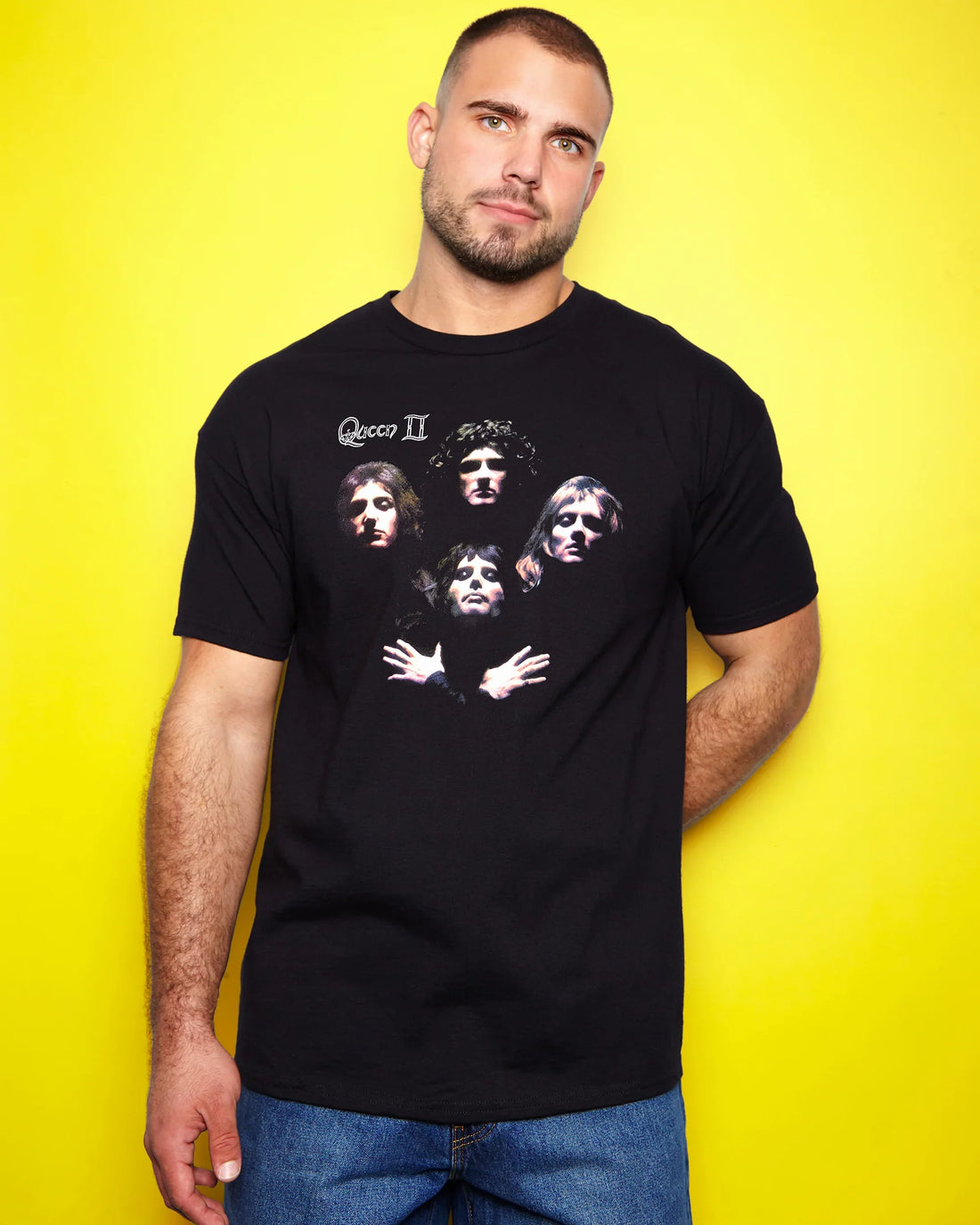 Man wearing a black t-shirt with Queen Bohemian Rhapsody design against a yellow background