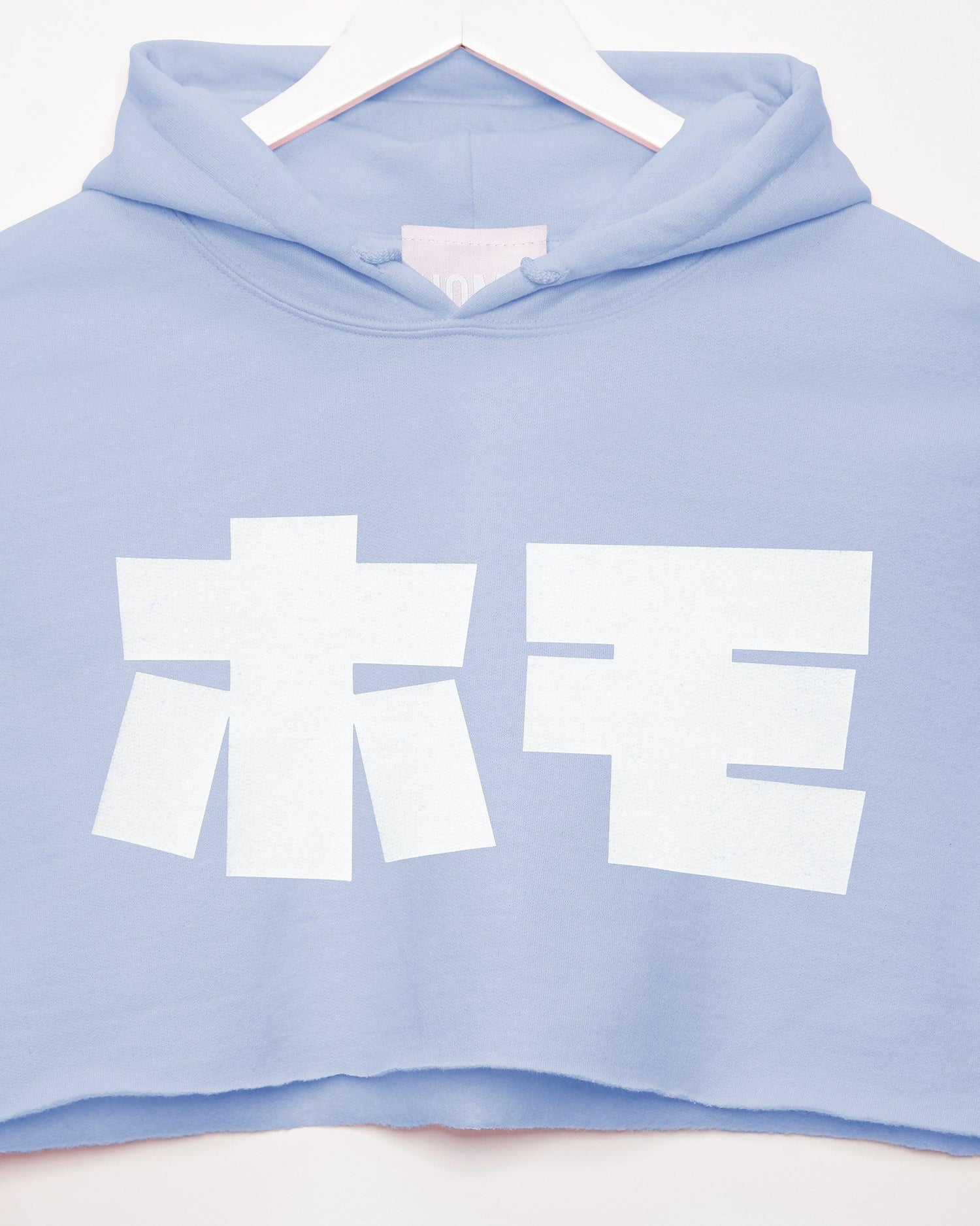 HOMO in Japanese white on light blue hoodie crop top. HOMOLONDON